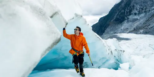 Man exploring an ice cave during a helihike at Fox Glacier on the West Coast