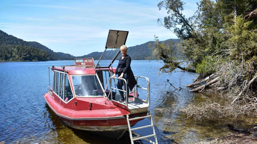 Woman disembarking from boat during Lake Mapourika Cruise and Walk tour in New Zealand