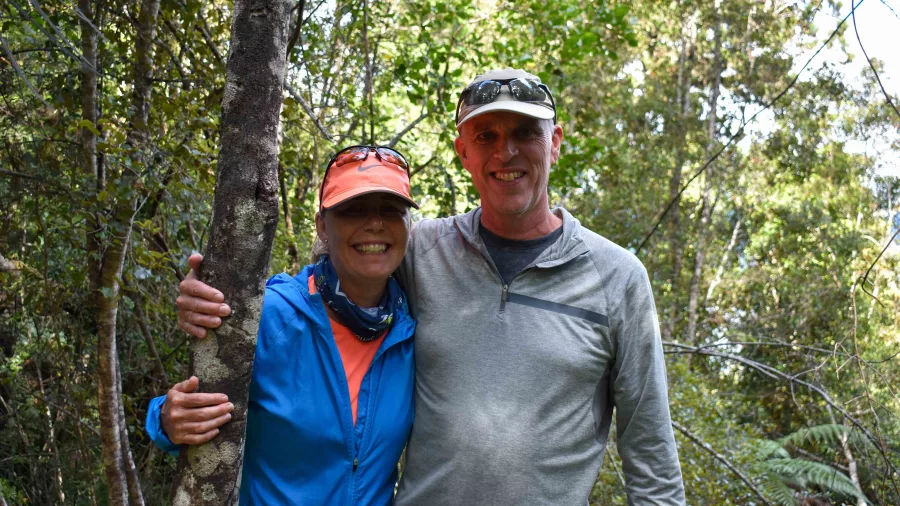 Smiling couple standing together on a forest trail during a Franz Josef Cruise and Walk tour