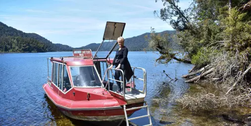 Woman disembarking from boat during Lake Mapourika Cruise and Walk tour in New Zealand