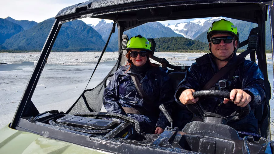Couple inside an off-road buggy during a scenic adventure near Franz Josef on New Zealand’s West Coast