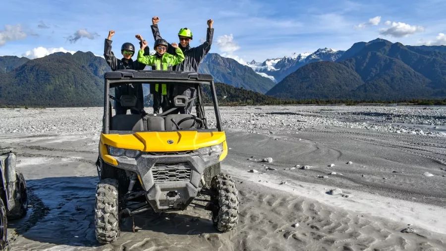 Family on an off-road buggy tour near Franz Josef Glacier on the West Coast of New Zealand