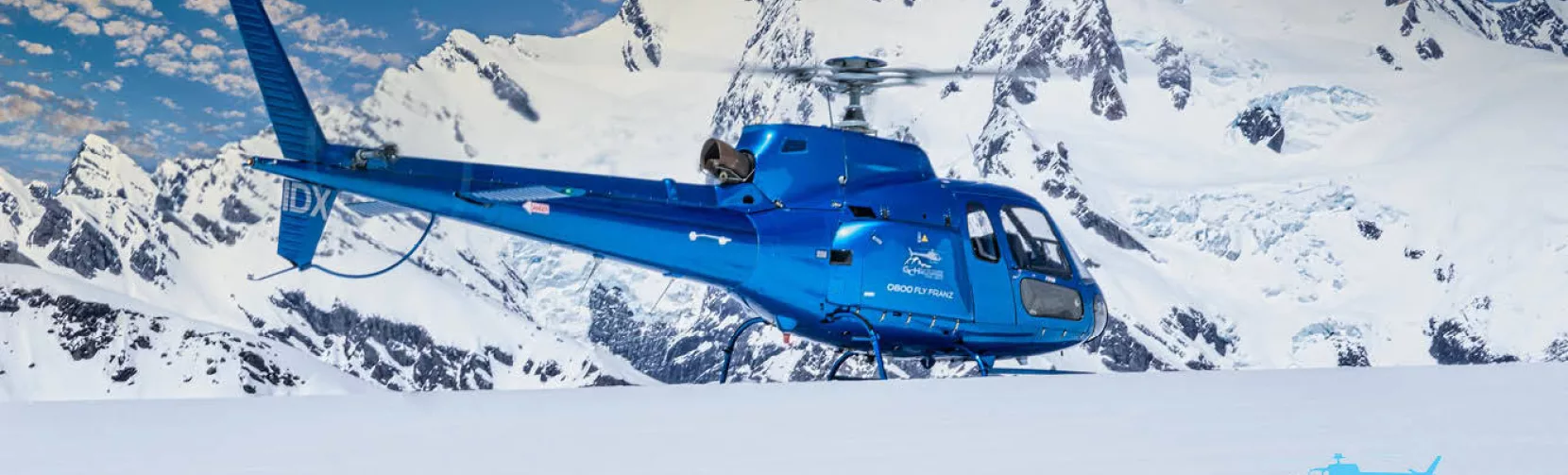 Glacier Country Helicopters blue IDX helicopter during snow landing near Franz Josef