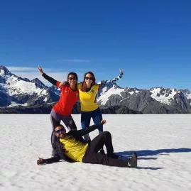 Three smiling people posing on the snow during a Middleton landing near Franz Josef with Glacier Country Helicopters