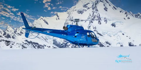 Glacier Country Helicopters blue IDX helicopter during snow landing near Franz Josef