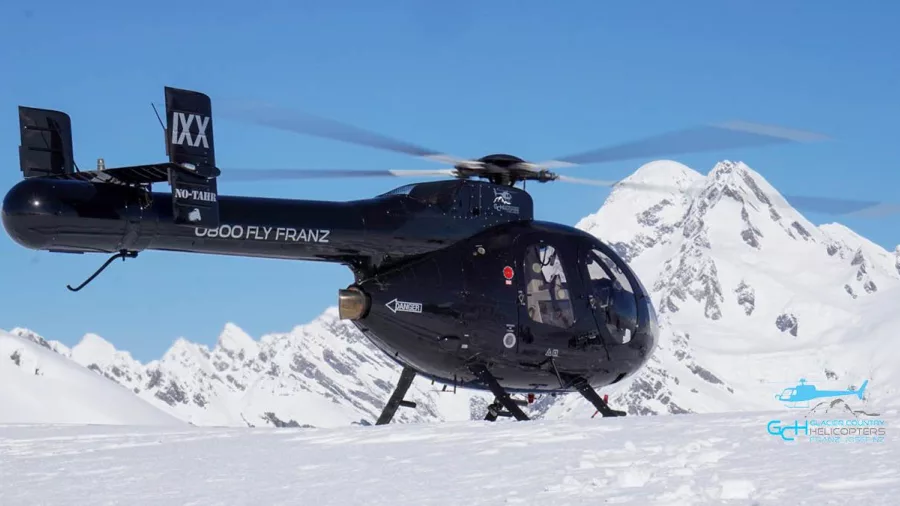 Glacier Country Helicopters NOTAR aircraft on snow landing at Franz Josef with Southern Alps in the background