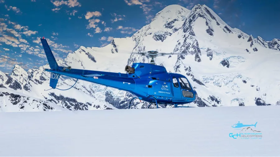 Glacier Country Helicopters blue IDX helicopter during snow landing near Franz Josef