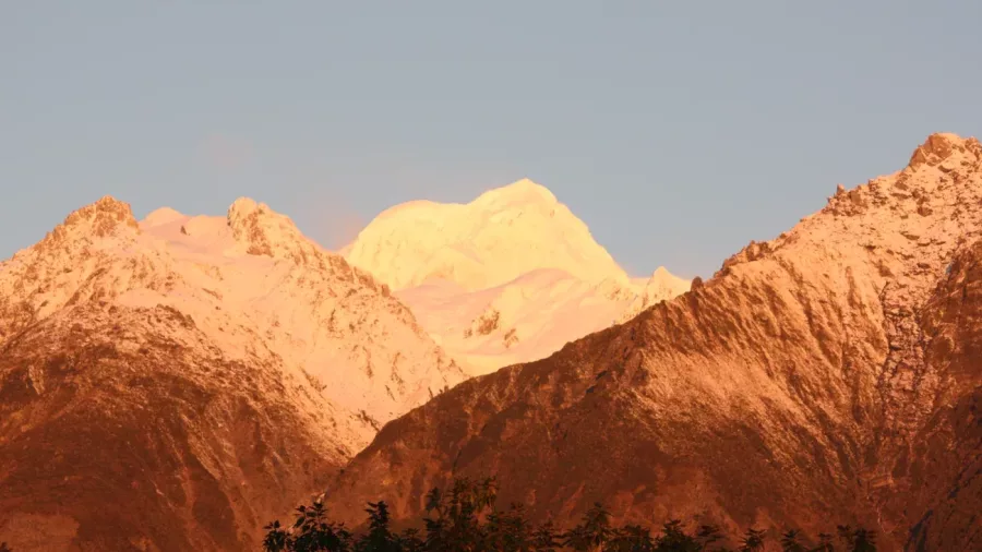 Snow-covered peaks glowing at sunset near Fox Glacier on New Zealand’s West Coast