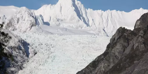 Snow-covered summit of Mount Tasman surrounded by rugged peaks on New Zealand’s West Coast