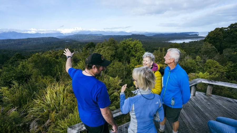 Guided nature tour group enjoying rainforest and Southern Alps views in Okarito, West Coast New Zealand