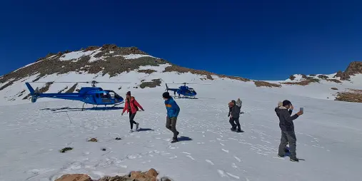 Travellers walk on snow after a helicopter landing in the Southern Alps from Franz Josef