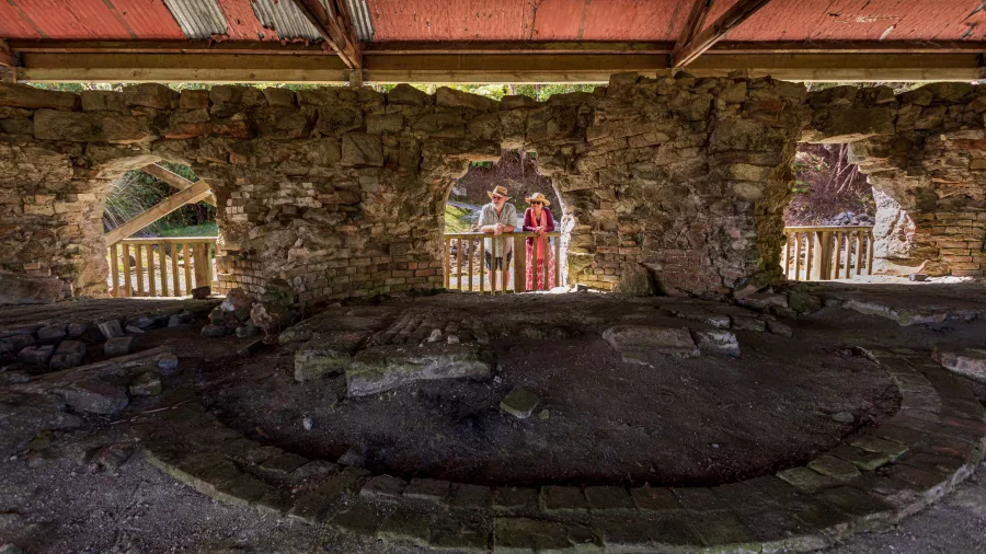 Visitors looking through the stone ruins of the Brunner Mine Site in Greymouth