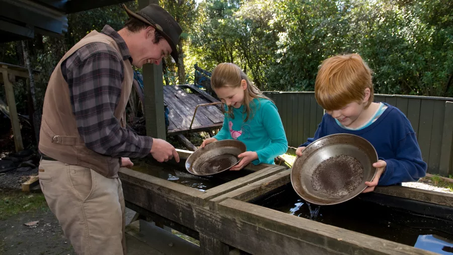 Children learning to gold pan with a guide at Shantytown Heritage Park in Greymouth on the West Coast.
