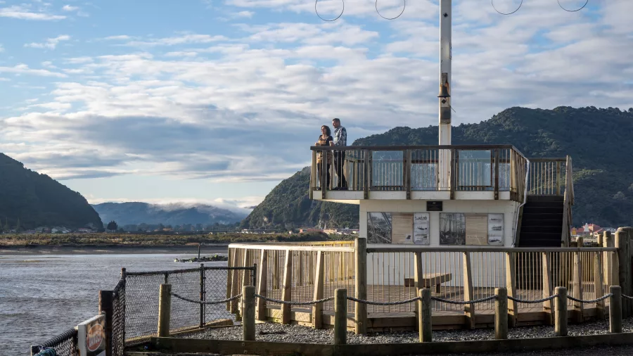 Couple standing on the viewing platform at Blaketown Tip Head in Greymouth overlooking the Grey River mouth