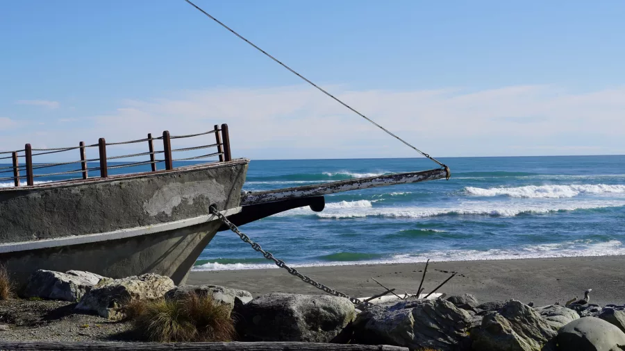 Concrete bow of the Tambo Shipwreck Memorial overlooking the beach in Hokitika