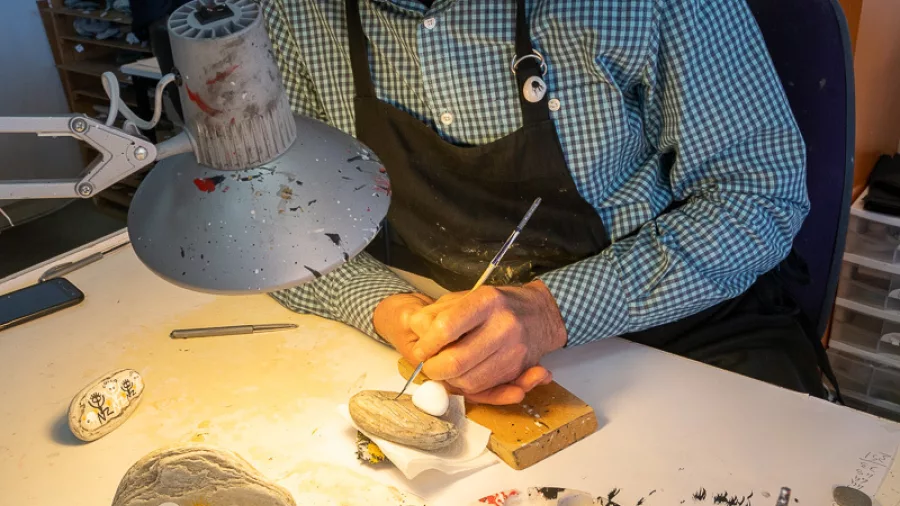 William Steyn hand-painting stone creatures in his Hokitika studio on the West Coast