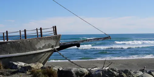 Concrete bow of the Tambo Shipwreck Memorial overlooking the beach in Hokitika