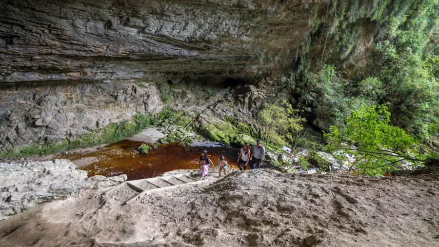 Family climbing sandy steps at the Ōpārara Arches in Karamea, West Coast