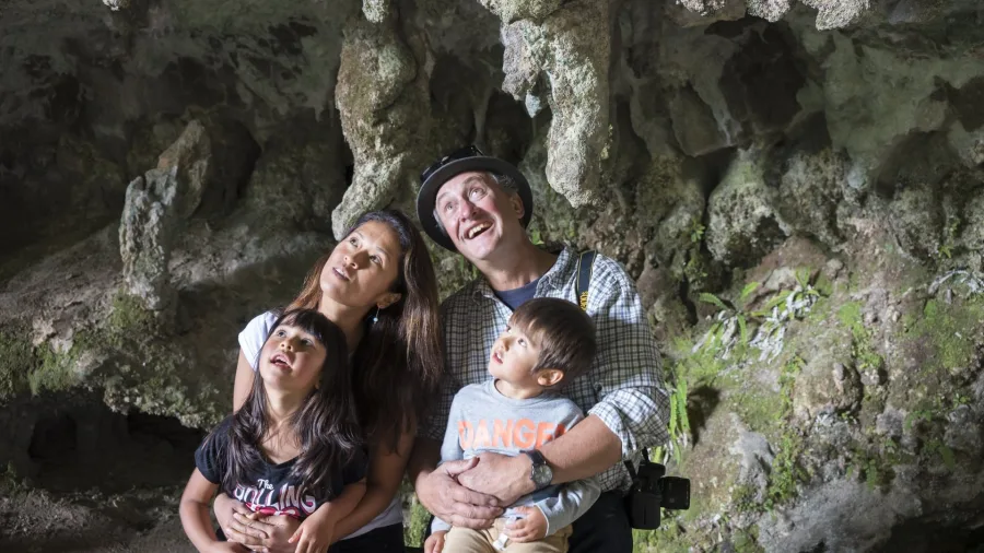 Family exploring inside Oparara Arch and caves, Karamea