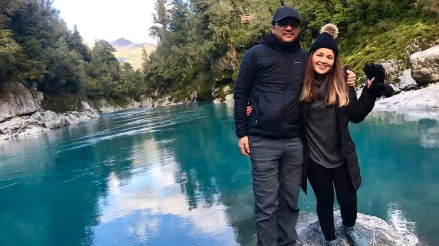 Couple posing by the turquoise waters of Hokitika Gorge, West Coast New Zealand