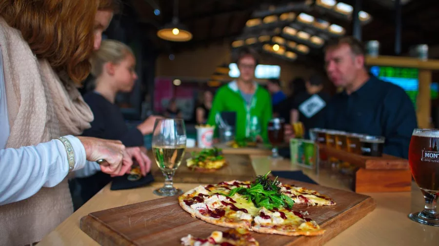 Guests enjoying wood-fired pizzas and craft beer at Monteith’s Brewery in Greymouth on the West Coast