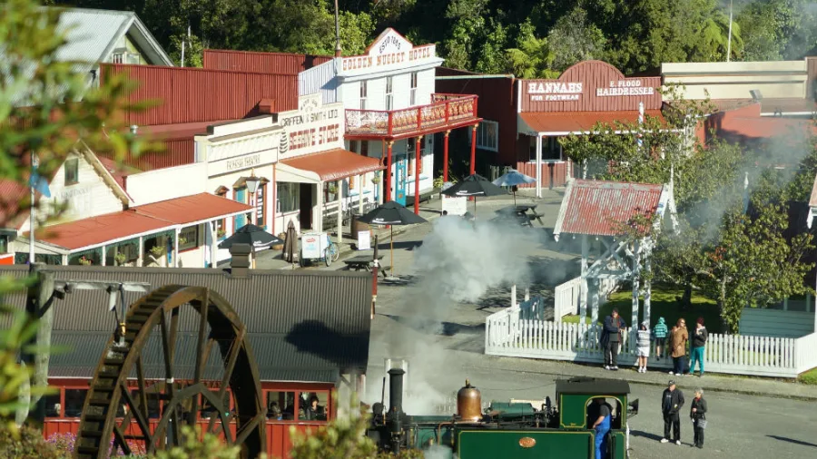 A view over Shantytown Heritage Park’s historic main street with a steam train passing through