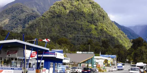 Scenic view of Franz Josef township with lush West Coast hills in the background