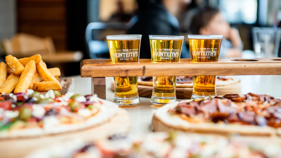 Close-up of beer tasting tray with fries and pizzas at Monteith’s Brewery