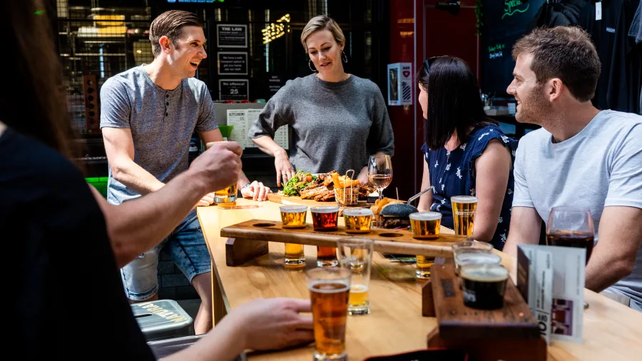 Group enjoying craft beers and food during a tasting session at Monteith’s Brewery