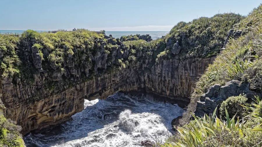 Waves crashing through natural sea arches at the Punakaiki Blowholes in Paparoa National Park