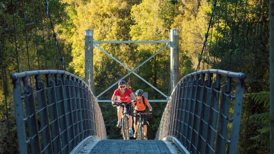 Cyclists crossing the Kawhaka bridge on the West Coast Wilderness Trail