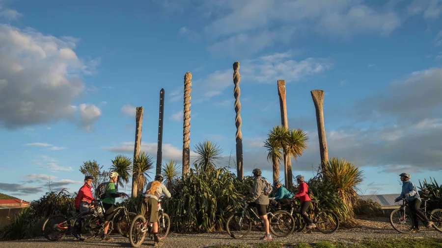 Cyclists stopping at the mining sculpture installation on the Greymouth Floodwall