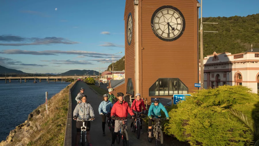 Cyclists riding past the Greymouth Clocktower on the West Coast Wilderness Trail