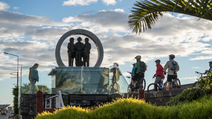 Cyclists gathered beside the Miners’ Memorial on the Greymouth Floodwall in New Zealand