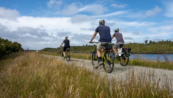 Cyclists riding along the West Coast Wilderness Trail near Greymouth on a clear day