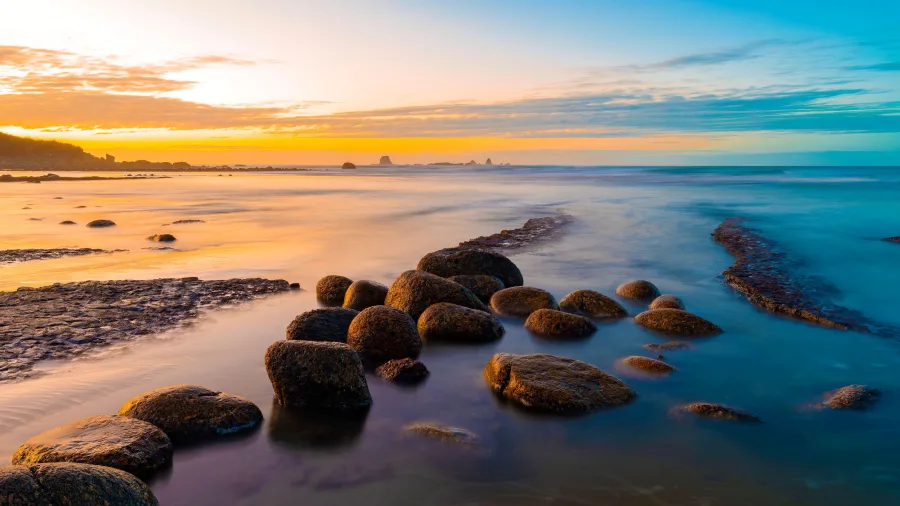 Rocky shoreline at Cape Foulwind glowing in golden light on New Zealand’s West Coast